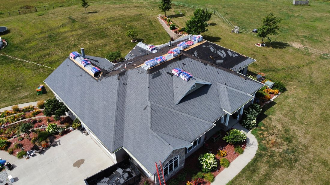 Aerial view of a roof mid-repair with materials staged for the job