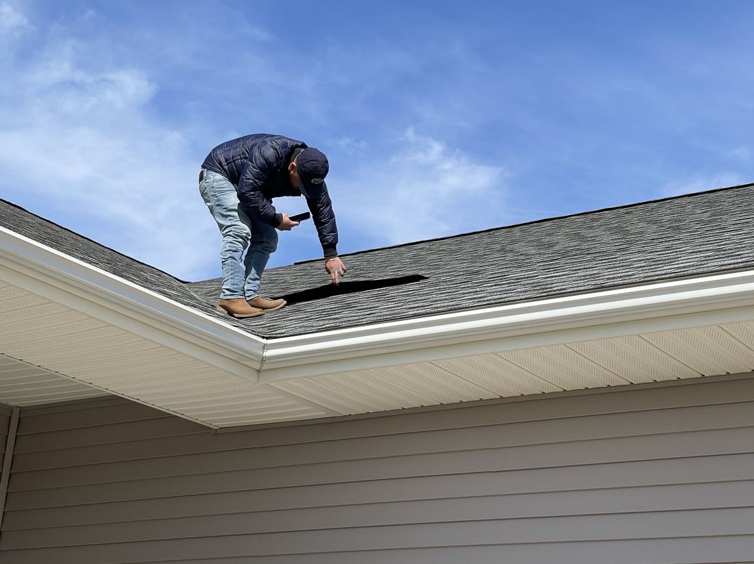 Trego Roofing crew member installing shingles