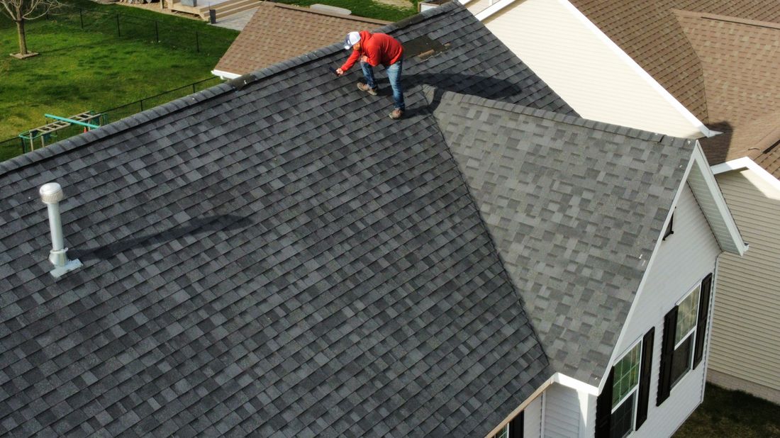 Aerial view of a Trego Roofing crew member at work on a roof