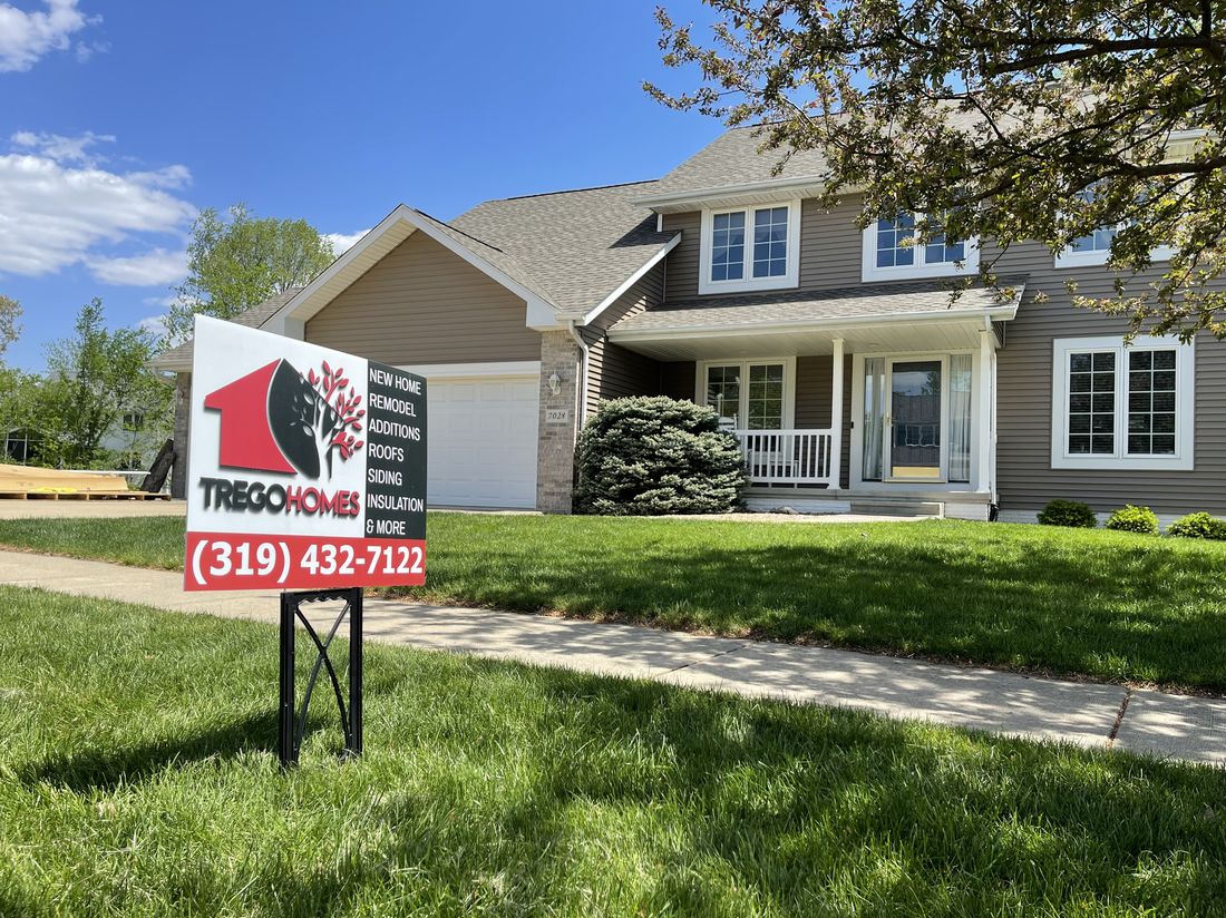 Completed roof on a two-story home with a Trego Homes yard sign out front