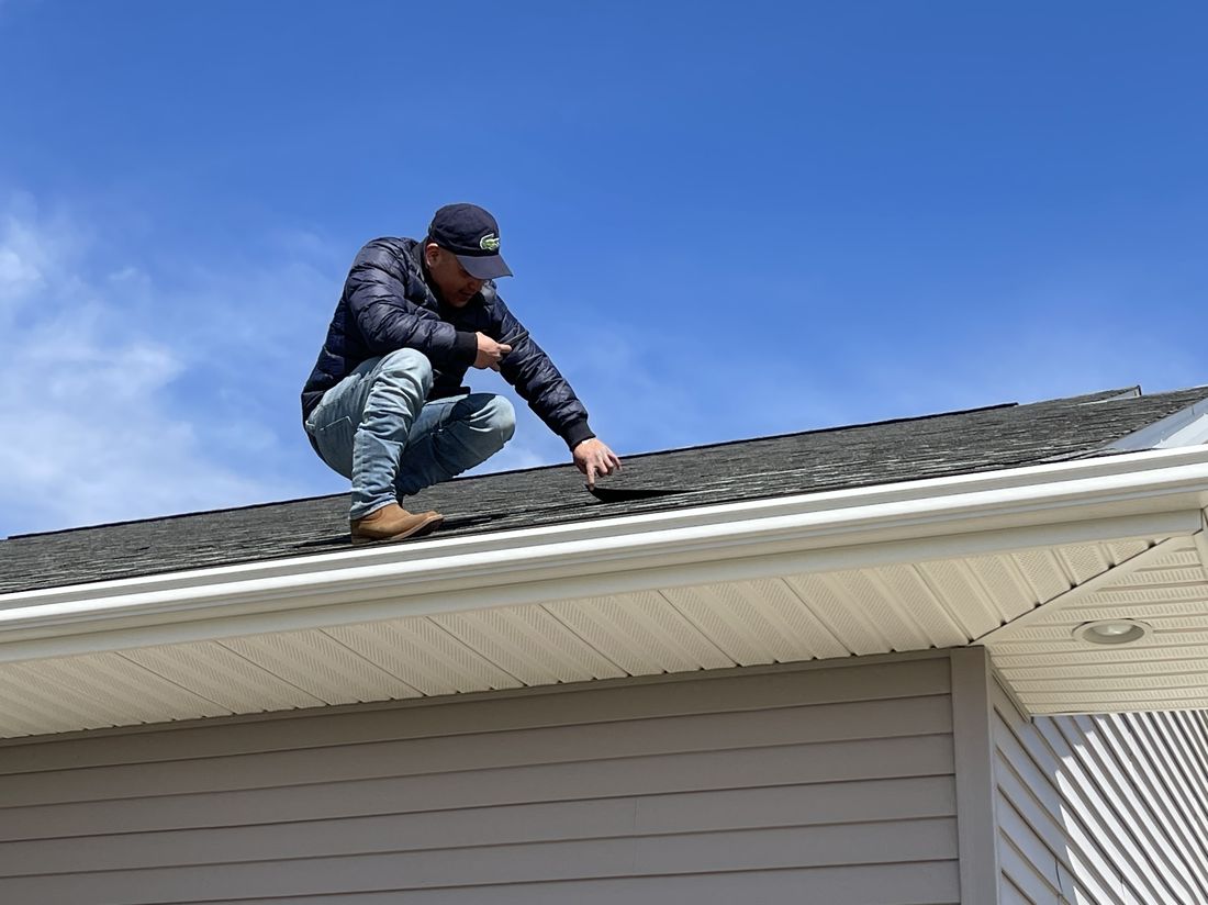 Trego Roofing crew member making a close-up shingle repair
