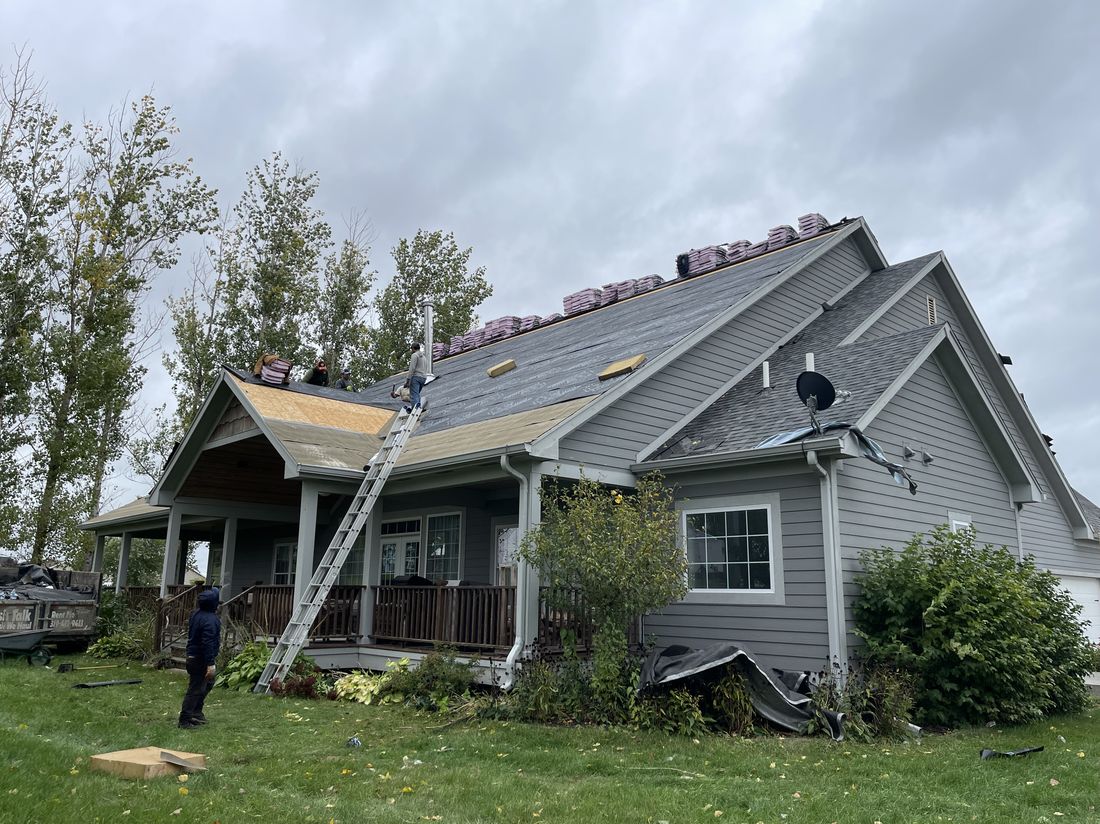 Trego Roofing crew mid tear-off during a full roof replacement