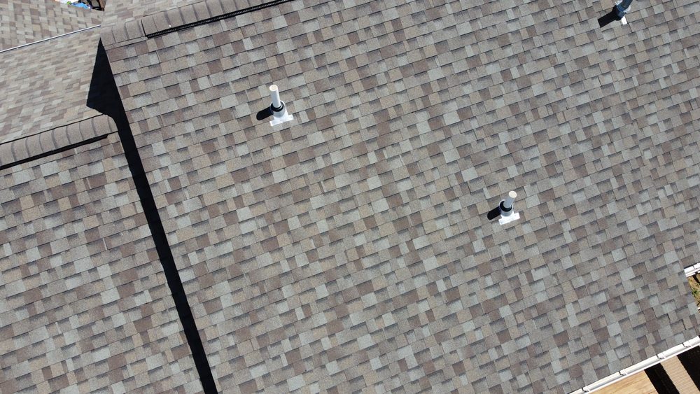 Aerial detail shot of a shingle roof with vent boots, Trego Roofing