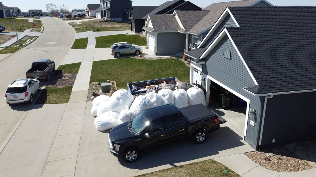 Roofing material bundles staged in a driveway before installation